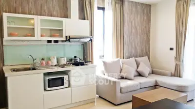 Modern open-layout kitchen and living room with stylish decor and natural light.