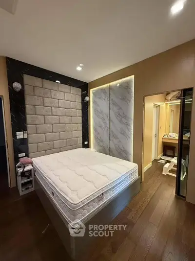 Modern bedroom with stylish accent wall and cozy lighting