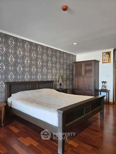 Elegant bedroom with wooden furniture and stylish wallpaper