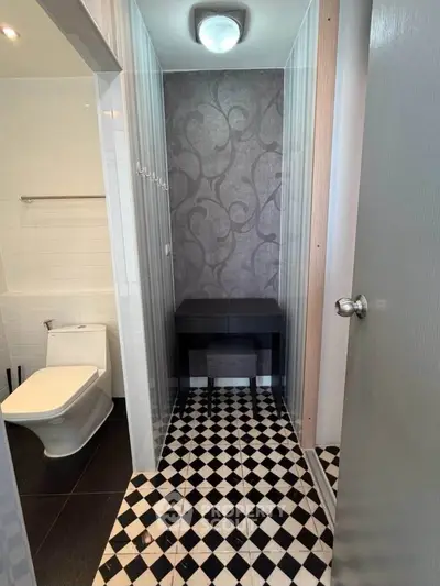 Stylish bathroom with modern fixtures and elegant black-and-white tile flooring.