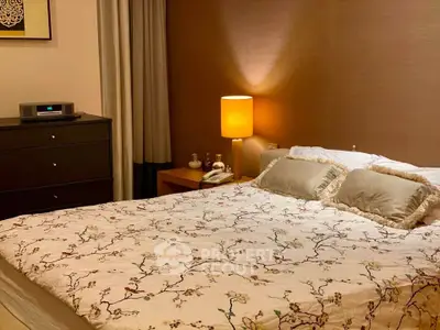 Cozy bedroom with elegant decor and soft lighting, featuring a stylish dresser and comfortable bedding.