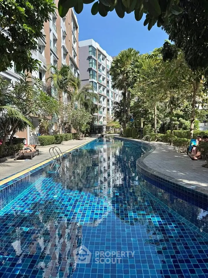 Luxurious residential pool surrounded by lush greenery and modern architecture.
