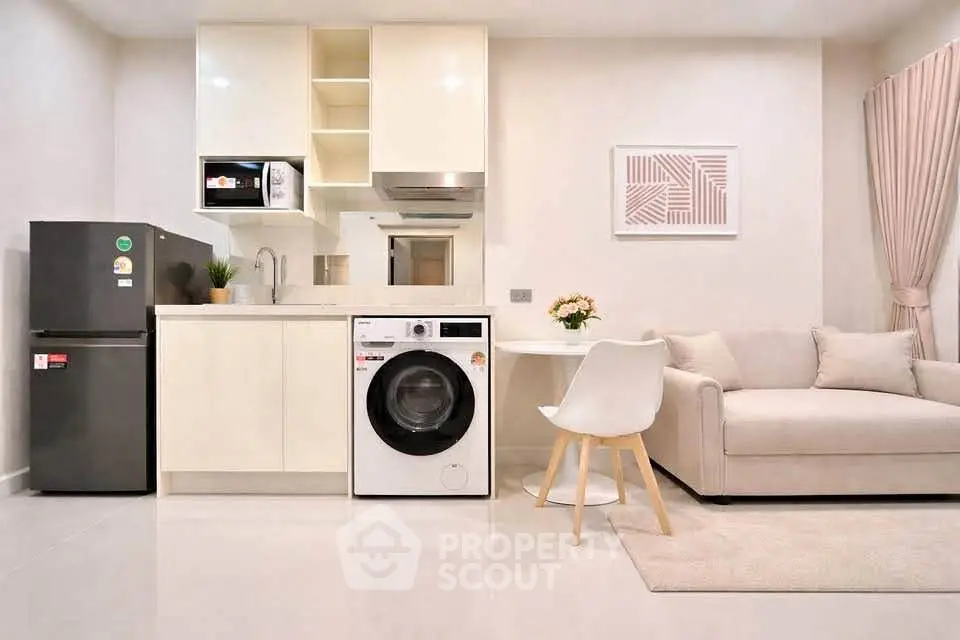 Modern open-layout kitchen and living room with sleek appliances and cozy seating area.