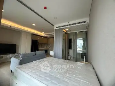 Modern studio apartment with open layout, featuring a cozy living area and sleek kitchen design.