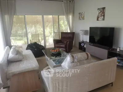 Spacious living room with modern furniture and garden view, perfect for relaxation and entertainment.