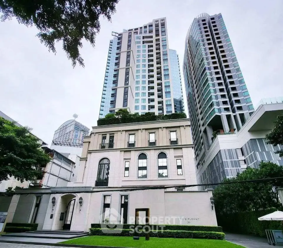 Luxurious high-rise building with modern architecture and lush greenery in urban setting.