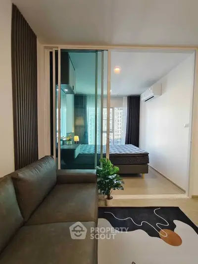 Modern apartment interior with cozy living room and stylish bedroom, featuring sleek design and natural light.