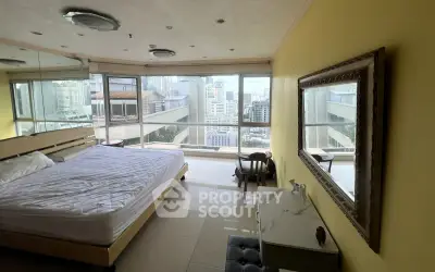 Spacious bedroom with city view and elegant decor in high-rise apartment.