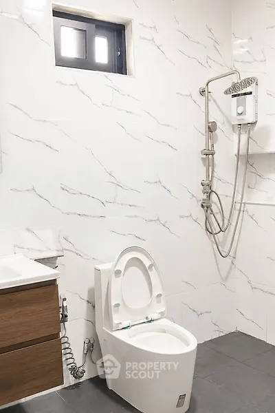 Modern bathroom with sleek white fixtures and elegant marble tiles.