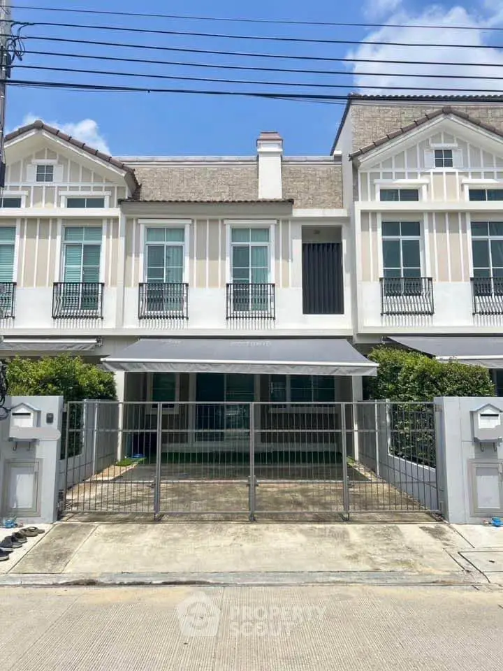 Charming townhouse with modern facade and gated driveway in a serene neighborhood.