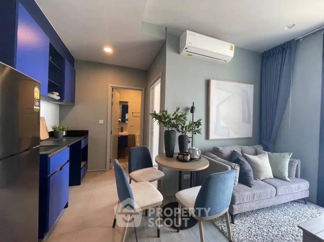 Modern living room with open kitchen, stylish decor, and cozy seating area.