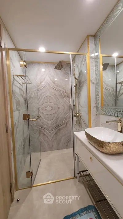 Luxurious bathroom with elegant marble shower and gold accents