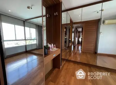 Spacious mirrored hallway with wooden flooring and modern decor