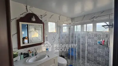 Luxurious bathroom with elegant marble walls and modern shower enclosure