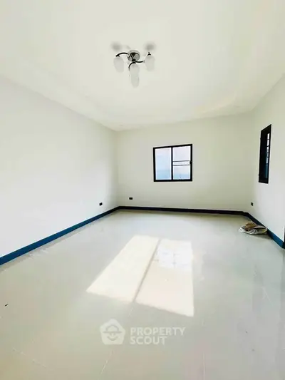 Spacious empty room with large windows and modern lighting, perfect for customization.