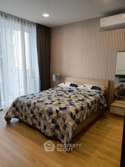 Modern bedroom with stylish decor and large window for natural light.