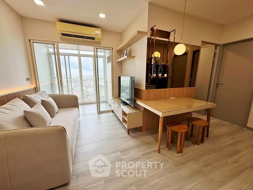 Modern living room with large windows and city view, featuring cozy sofa and stylish decor.