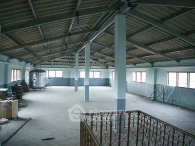 Spacious industrial loft with high ceilings and ample natural light, ideal for creative workspace or storage.