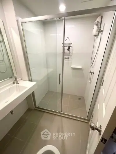 Modern bathroom with glass shower enclosure and sleek fixtures