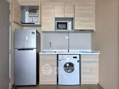 Modern compact kitchen with fridge, microwave, and washing machine in sleek wooden cabinetry.