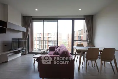 Modern living room with large windows and stylish furniture in a contemporary apartment.