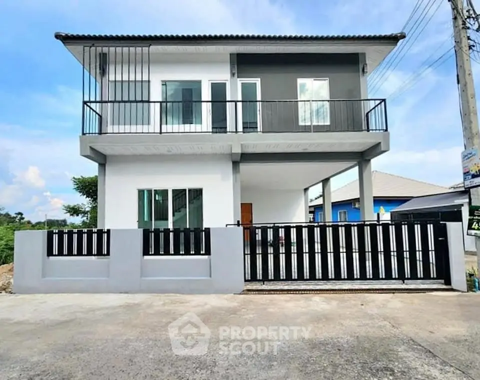 Modern two-story house with sleek balcony and gated entrance