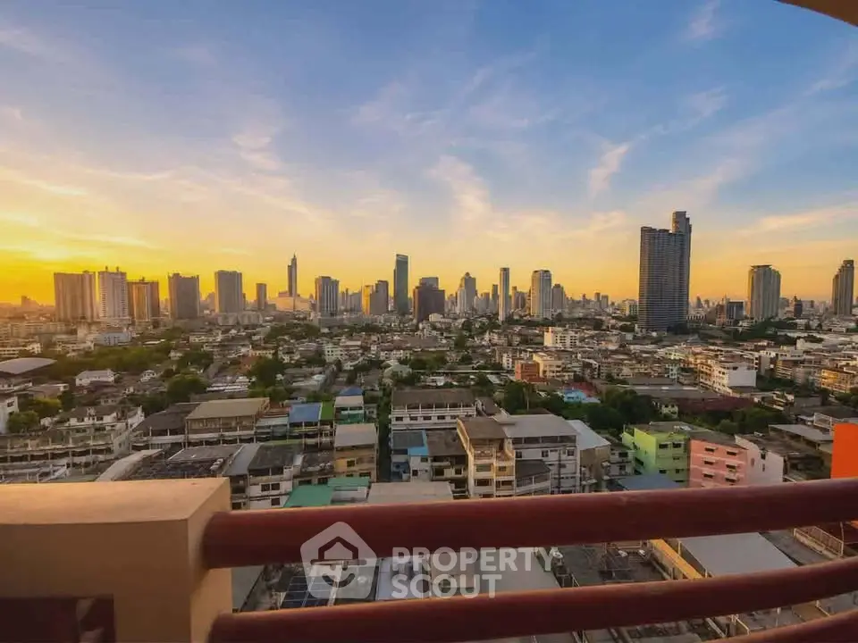 Stunning cityscape view from a high-rise balcony at sunset, showcasing urban skyline and vibrant colors.