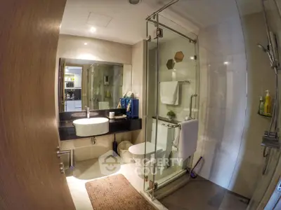 Modern bathroom with glass shower and sleek fixtures in a contemporary home.