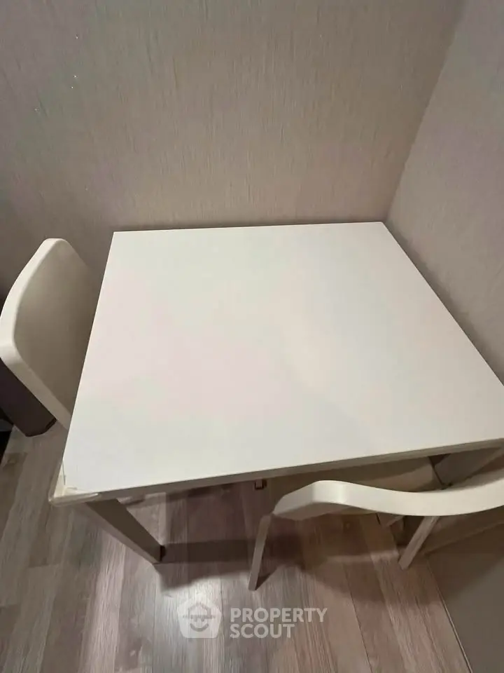 Cozy dining nook with modern white table and chairs, perfect for intimate meals in a compact space.