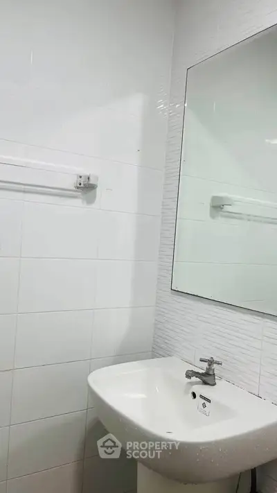 Modern bathroom with sleek white sink and large mirror