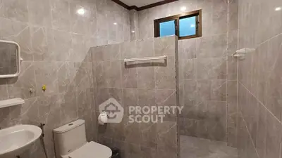 Spacious tiled bathroom with modern fixtures and natural light