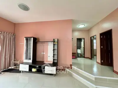 Spacious living area with modern entertainment unit and adjacent bathroom, ideal for comfortable living.