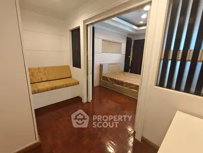 Modern bedroom with wooden flooring and cozy seating area