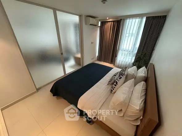 Modern bedroom with stylish decor and frosted glass partition