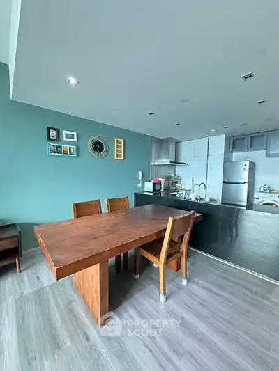 Modern kitchen with wooden dining table and sleek appliances in open layout