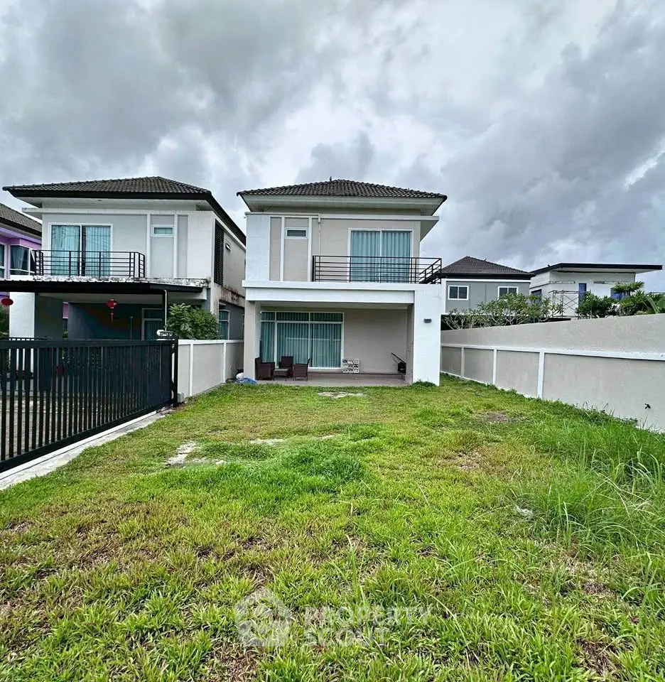 Spacious two-story house with lush green lawn and modern exterior design.