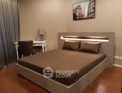 Modern bedroom with stylish bed and desk, featuring warm lighting and elegant decor.