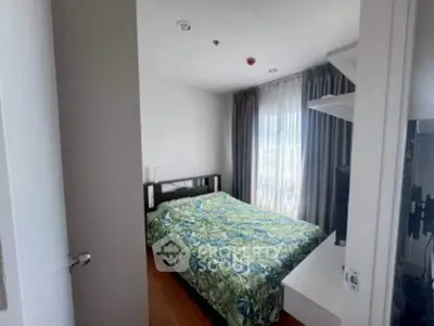 Cozy bedroom with vibrant bedding and natural light from large window.