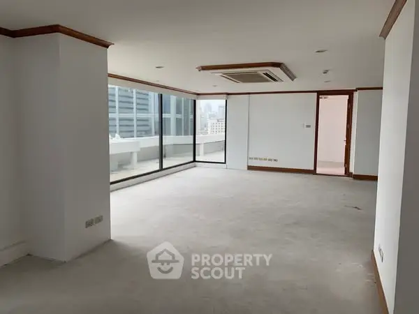 Spacious unfurnished living room with large windows and city view