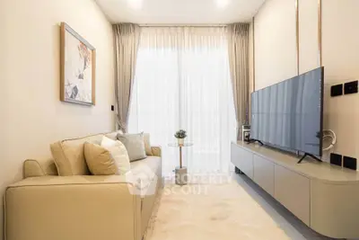 Modern living room with sleek furniture and large TV, featuring elegant curtains and stylish decor.