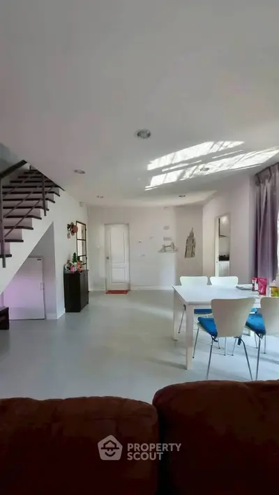 Spacious modern living room with dining area and staircase