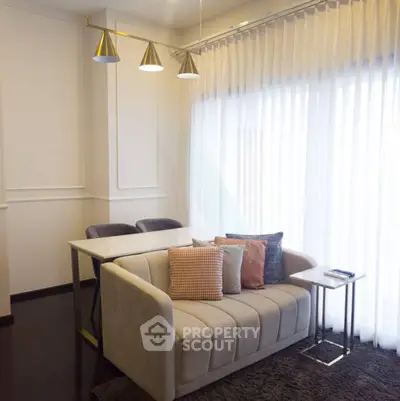 Stylish modern living room with elegant sofa and dining area, featuring chic lighting and floor-to-ceiling curtains.