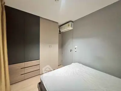 Modern bedroom with sleek wardrobe and air conditioning in stylish apartment.