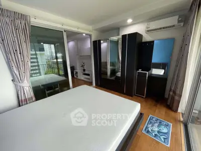 Modern bedroom with large windows and stylish furniture in a high-rise apartment.