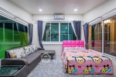Spacious bedroom with large windows and modern decor, featuring a cozy bed and stylish sofa.