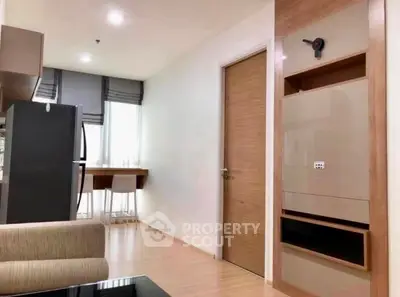 Modern apartment interior with sleek kitchen and cozy living area, featuring stylish wood accents and natural light.