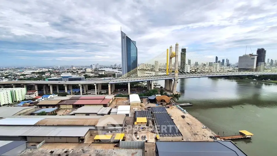 Stunning aerial view of modern cityscape with iconic bridge and river, showcasing urban development and architecture.