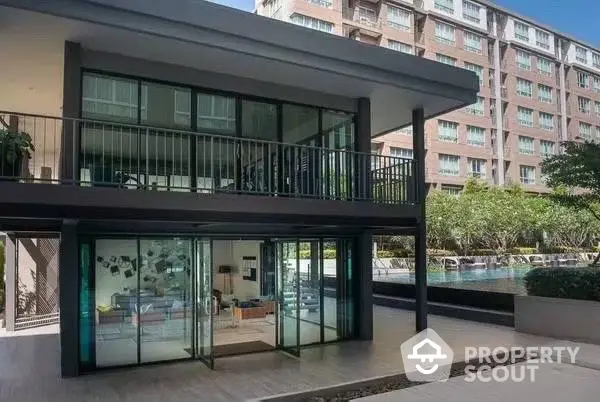 Modern two-story building with large glass windows and poolside view