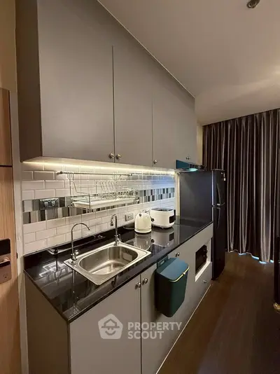 Modern compact kitchen with sleek cabinetry and stainless steel appliances