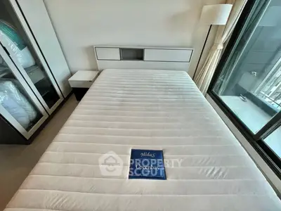Modern bedroom with large window and stylish furnishings in a high-rise apartment.
